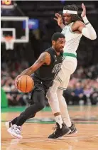  ?? Maddie Meyer/Getty Images ?? Nets guard Kyrie Irving drives towards the basket past the Celtics’ Robert Williams III during the first half on Wednesday in Boston.