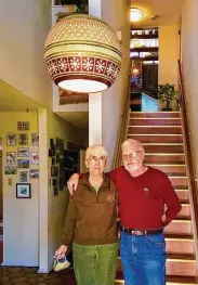  ??  ?? Rick and Pat Kendrick stand under the Beaumont Mood Lighting globe lamp they bought in 1978. It hangs in the foyer of their San Antonio home.