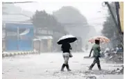  ?? DELMER MARTINEZ/AP ?? Women walk under umbrellas in the rain brought by Hurricane Iota on Tuesday in La Lima, Honduras.