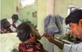  ??  ?? In this photograph, barber Mohammad Shadat Hossain applies henna to the beard of his client Abdur Rahman in Dhaka.