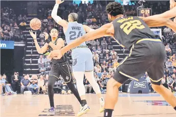  ?? — AFP photo ?? Jordan Poole (left) of the Golden State Warriors looks to pass to Andrew Wiggins (right) against Dillon Brooks (centre) of the Memphis Grizzlies during the first half at FedExForum in Memphis, Tennessee.