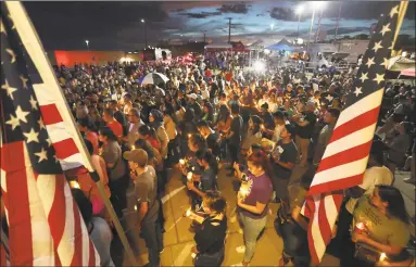  ?? Getty Images ?? People attend a candleligh­t vigil at a makeshift memorial honoring victims of a mass shooting which left at least 22 people dead, on Wednesday in El Paso, Texas.