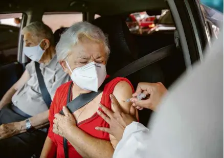  ?? Danilo Verpa/Folhapress ?? Mulher é imunizada no drive-thru no estádio do Morumbi, onde o governador João Doria esteve presente