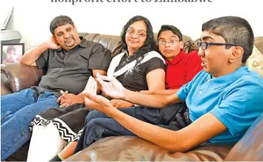  ?? STAFF PHOTO BY ROBIN RUDD ?? Philip Mathews, far right, talks about the experience of holding a child who has a cleft palate, while father, Santhosh, mother, Susan, and brother, Caleb, listen.