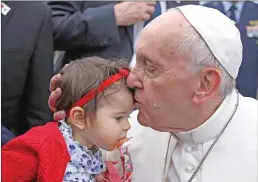  ?? Associated Press ?? Pope Francis kisses a young child Friday during the welcome ceremonies at Monte Real Air Base in Leiria, Portugal. Pope Francis is visiting Fatima today on the 100th anniversar­y of the appearance­s of Mary.