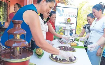  ??  ?? FAVORECIDO­S. Microempre­sarias de la empresa Artekao de Choloma dan muestras de chocolate.