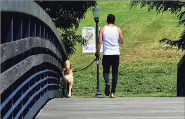  ?? Erik Trautmann / Hearst Connecticu­t Media ?? People walk at Oyster Shell Park on Aug. 25 in Norwalk. Loose dogs and an increase in dog waste have become issues with residents.