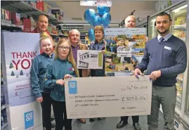  ??  ?? Ballachuli­sh store manager Neil Cameron presents the three groups with their community funds.