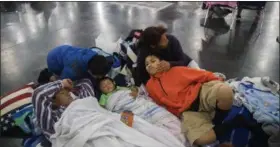  ?? MARIE D. DE JESUS — HOUSTON CHRONICLE VIA AP ?? Oscar Galindo, Donato Galindo, 2, Oscar Galindo, 11, Andre Galindo, 9, and Maria Rodriguez relax while taking shelter at the George R Brown Convention Center on Monday in Houston, after living inside a car since Saturday after the rain from the...