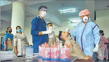  ??  ?? A health care worker collects swab sample at a Covid-19 testing camp in Patiala on Monday