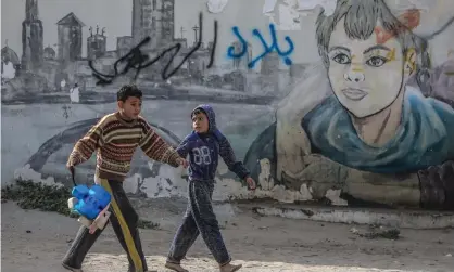  ?? Photograph: Mohammed Saber/EPA ?? Palestinia­n refugee boys play in the streets of a refugee camp in Gaza City this month.