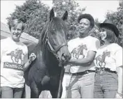  ?? Ira Schwarz Associated Press ?? PART OF THE SLEW CREW, with the matching T-shirts to prove it, are, from left, owner Mickey Taylor, groom John Polston and owner Karen Taylor.