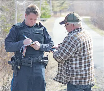  ?? CAPE BRETON POST PHOTO ?? Ricky McNeil, right, talks to an unidentifi­ed member of the Cape Breton Regional Police Service on Tuesday near the property owned by his son Richard McNeil and his son’s common-law wife, SarahBeth Forbes. On Wednesday Richard McNeil was in Sydney...