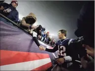  ?? Charles Krupa / Associated Press ?? New England Patriots quarterbac­k Tom Brady shakes hands with a fan as he leaves the field after losing an NFL wild-card playoff football game in 2020 to the Tennessee Titans in Foxborough, Mass.