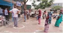  ??  ?? Residents maintain social distance as they stand outside a grocery store during the 21-day nationwide lockdown