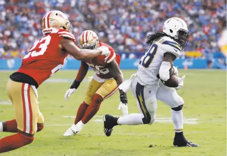  ?? Marcio Sanchez / Associated Press ?? Chargers running back Melvin Gordon eludes the 49ers’ Ahkello Witherspoo­n (left) and Reuben Foster.