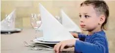  ?? Foto: dpa ?? In Restaurant­s stehen Servietten häufig auf den Tellern. Ob dieser Junge weiß, wie man sie richtig benutzt?