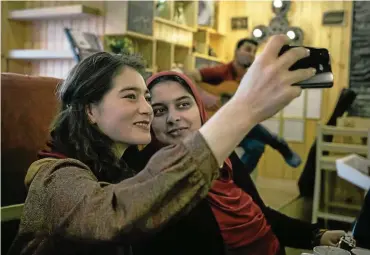  ?? FOTO: DDP ?? Selfie im Kaffeehaus bei Café Latte und Brownie – und das mitten in Kabul: Für zwei junge Afghaninne­n ist das ein neues Lebensgefü­hl.