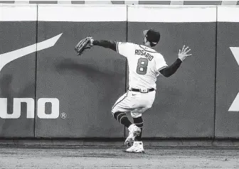  ?? Brett Coomer / Staff photograph­er ?? Braves left fielder Eddie Rosario catches a fly out from Astros second baseman Jose Altuve to end the top of the eighth inning. Altuve had homered earlier in the game.