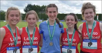  ??  ?? Róisín O’Reilly of Loreto (Wexford), silver medal winner in the Inter girls steeplecha­se, is flanked by the school’s bronze-winning Inter relay team.