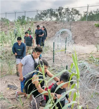  ?? AFP ?? Migrantes de Perú caminan junto a la orilla de Río Grande, en Eagle Pass, Texas