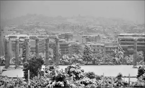  ?? AP Photo/Thanassis Stavrakis ?? Snow covers the ancient temple of Zeus in Athens, on Tuesday.