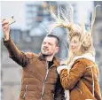  ??  ?? A couple in Edinburgh have their selfie thwarted by Storm Dennis’s strong winds