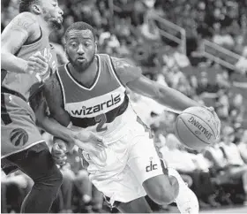  ?? NICK WASS/ASSOCIATED PRESS ?? Wizards guard John Wall drives against Raptors guard Norman Powell in a preseason game Friday. Wall made six of nine 3-point attempts in the final two preseason games.