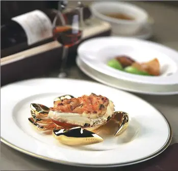  ?? PHOTOS PROVIDED TO CHINA DAILY ?? T’ang Court’s dishes for the Chinese New Year include sauteed sliced lobster with crab roe ( top) and baked seafood rice with cream sauce in crab shell ( above).