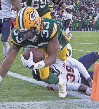  ?? MARK HOFFMAN / JOURNAL SENTINEL ?? Packers running back Aaron Jones scores a touchdown on a 21-yard run despite the efforts of Bears safety Eddie Jackson.