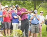  ?? David Dermer / Associated Press ?? Tiger Woods follows through on his swing on Wednesday.