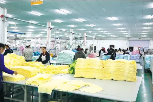  ?? PROVIDED TO CHINA DAILY ?? Ethnic minority workers pack towels at a factory in Xinjiang Xinyuesilu Co Ltd.