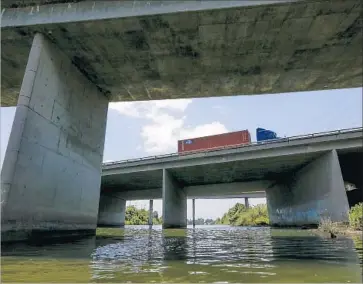  ?? Photograph­s by Mark Boster Los Angeles Times ?? A BIG RIG moves along the 405 Freeway where it crosses the San Gabriel River near Seal Beach. Department of Transporta­tion engineers are inspecting the pillars and supports of the 53-year-old span for erosion.