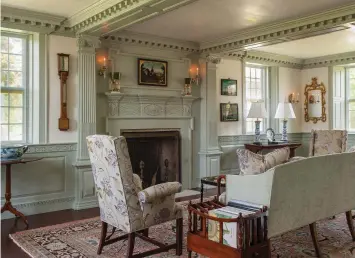  ??  ?? LEFT The living room’s Georgian elements include a fireplace with a bolection moulding surround, pilasters with Corinthian capitals, deep dentil moulding, and a paneled wainscot. Two summer beams accentuate the fireplace wall.