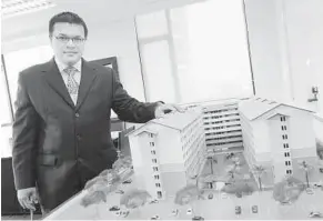  ??  ?? Kamarul with a model of an affordable housing project by SPNB. Since 2008, total sales under the affordable housing programme totalled 14,326 units, with a developmen­t value of RM1.56bil.