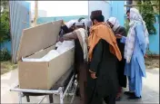  ?? (AP/Sidiqullah Khan) ?? In Kandahar, Afghans mourn over the body of Nimat Rawan, a former Afghan TV presenter who was gunned down Thursday.