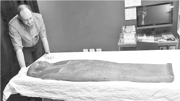  ??  ?? A 2,500-year old coffin that may contain a mummy lies at the University of Sydney in Sydney.