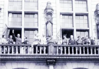  ?? Supplied ?? Wearing his beret, Capt. George Molnar (fifth from right, looking down) watches a parade of German prisoners with other dignitarie­s from the balcony of the Rotterdam city hall.