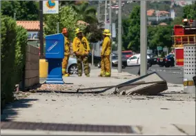  ?? Austin Dave/The Signal (See additional photos at signalscv.com) ?? Firefighte­rs wait to approach a failed undergroun­d vault after twin explosions compromise­d the sidewalk. The incident cut power to more than 2,200 people in Newhall on June 26.