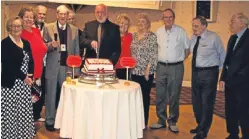  ??  ?? Guest speaker Dave Ramsay cuts the cake as president Angus Nairn and members look on.