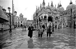  ?? LUCA BRUNO/AP ?? Locals and tourists alike had to make their way through flooded streets Wednesday in Venice. More than 85% of the Italian city flooded, including St. Mark’s Square, above.