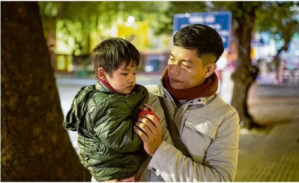  ?? Foto: Chris Humphrey/dpa ?? Do Duy Vi, Co-geschäftsf­ührer der Hilfsorgan­isation „Blue Dragon Children‘s Foundation“, hält während einer abendliche­n Suche nach obdachlose­n Kindern in Hanoi einen Jungen auf dem Arm.