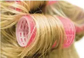  ?? DREAMSTIME ?? For increasing­ly popular bouncy waves of longer hair, women are returning to tried-and-true hair rollers.