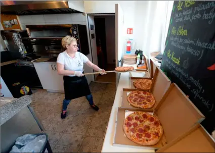  ?? AP Photo/Czarek Sokolowski ?? In this photo taken March 18 Bozena Legowska is making free pizzas for the doctors and medics of the Bielany hospital in Warsaw, Poland, as part of a nationwide action in a gesture of support for their unstopping fight against the spreading coronaviru­s.