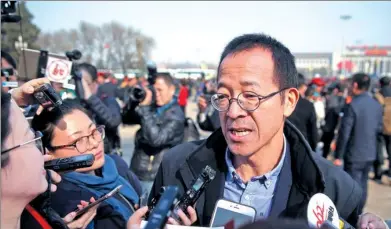  ?? HE HAI’ER / FOR CHINA DAILY ?? Yu Minhong answers questions in front of the Great Hall of the People in Beijing on Friday.