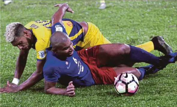  ?? PIC BY FARIZUL HAFIZ AWANG ?? Pahang’s Matheus Alves (top) brings down Darul Ta’zim’s Marcos Antonio during their Super League match on Tuesday. Darul Ta’zim won 2-0.