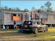  ?? (AP/The Sun Herald/Mary Perez) ?? Terry Watson measures a window for plywood Thursday at his in-law’s house in Vancleave, Miss., near the Gulf Coast after a tornado Wednesday blew out the windows in the home and his wife’s SUV parked out front.