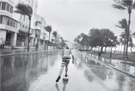  ?? David Goldman, The Associated Press ?? Funky Matas skateboard­s along South Beach as the effects of Hurricane Irma are felt in Miami Beach, Fla., on Saturday.