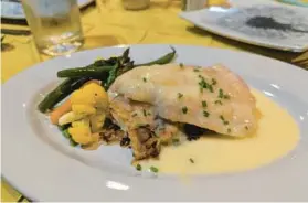  ?? STAFF ?? At a special dinner at Pierpoint Restaurant in Baltimore, chef Nancy Longo prepared a filet of Chesapeake blue catfish with chive beurre blanc sauce, served with potatoes au gratin and spring vegetables.
