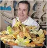  ?? HAMILTON SPECTATOR FILE PHOTO ?? Albertino Botelho holds a massive fish platter for two in this 2004 file photo.